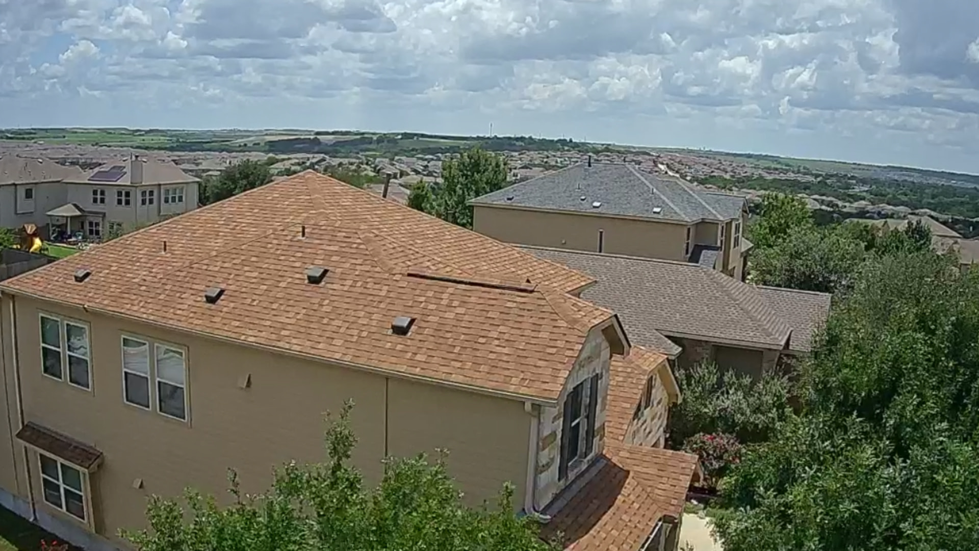 Warm-toned shingles on a hip roof